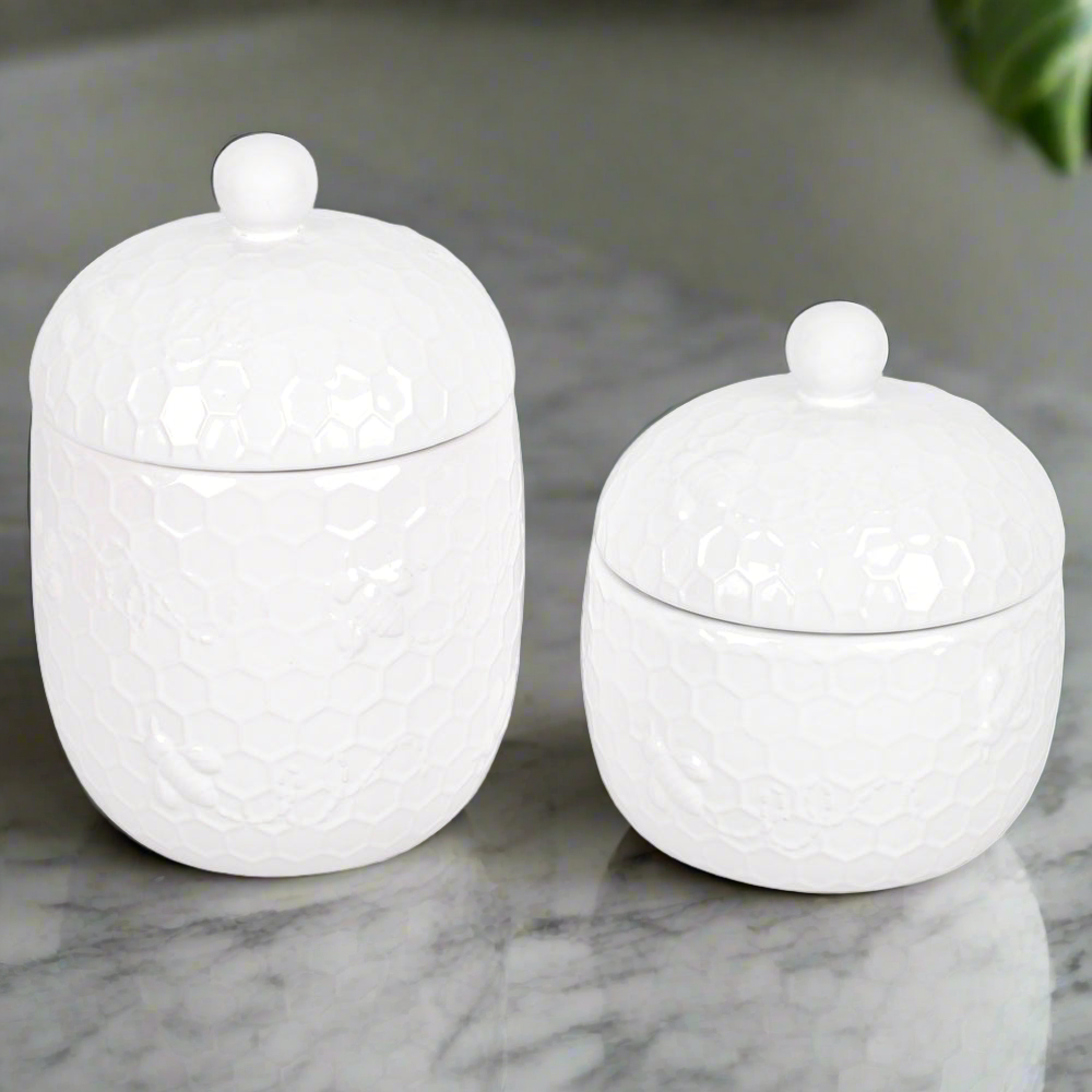 Ceramic storage canisters on a marble countertop in Temp-tations Bee-lieve pattern