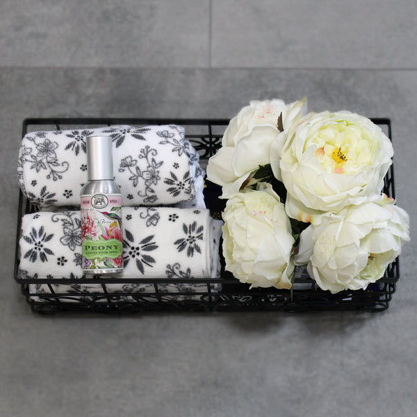 Temp-tations Metal Serving & Organizing Basket with Stoneware Trivet filled with hand towels and flowers in a guest bathroom